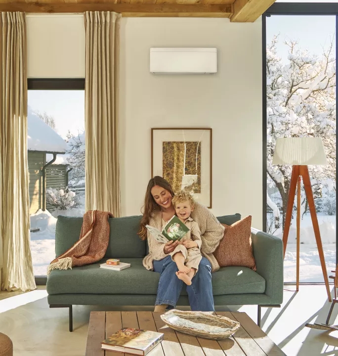 Springbok Agency campaign visual for Daikin, showing a happy mom and her baby in a clean modern interior with a Daikin indoor heating/cooling system in a bright, minimal space.
