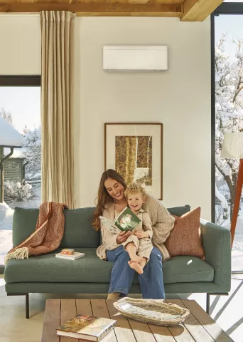 Springbok Agency campaign visual for Daikin, showing a happy mom and her baby in a clean modern interior with a Daikin indoor heating/cooling system in a bright, minimal space.